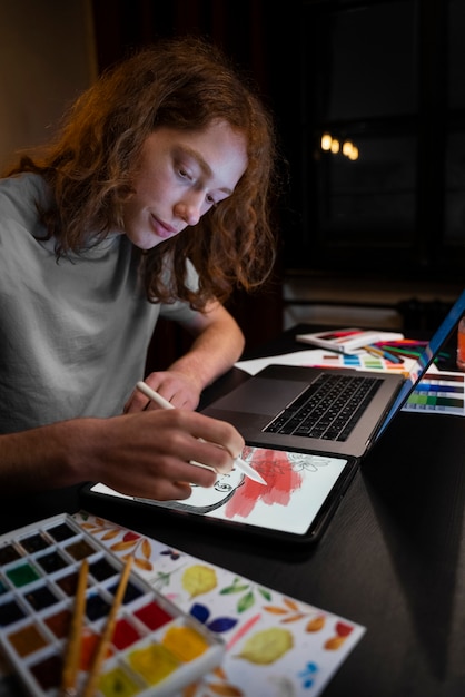 Бесплатное фото Вид сбоку женщина рисует на ipad
