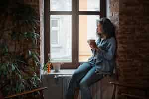 Free photo side view woman drinking coffee