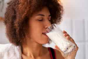 Бесплатное фото Вид сбоку женщина пьет молоко