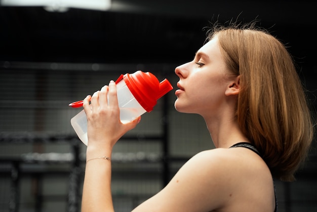 Бесплатное фото Боковой вид женщины питьевой воды