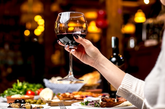 Вид сбоку женщина пьет стакан красного вина