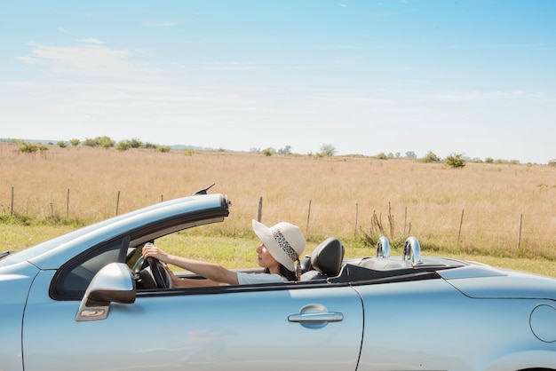 Free photo side view of woman driving cabriolet