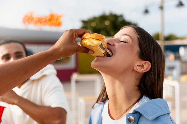 ハンバーガーを食べる側面図の女性