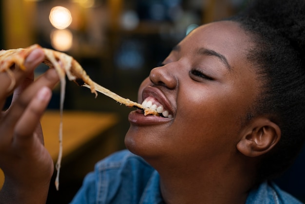 Donna di vista laterale che mangia in un modo divertente