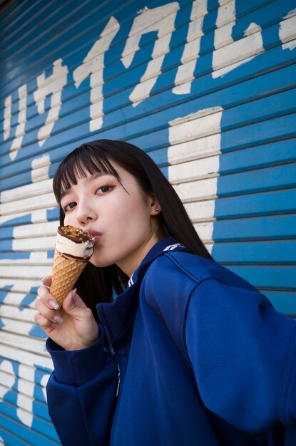 Вид сбоку женщина ест мороженое