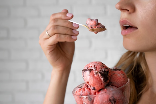 Foto gratuita donna di vista laterale che mangia il gelato