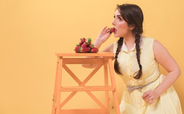 Side view of woman eating strawberries with copy space