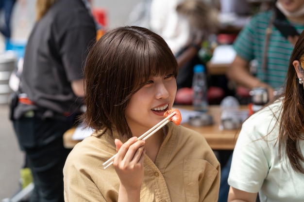 side view woman eating with chopsticks