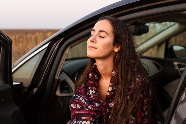 車の中で自然を楽しむ女性の側面図