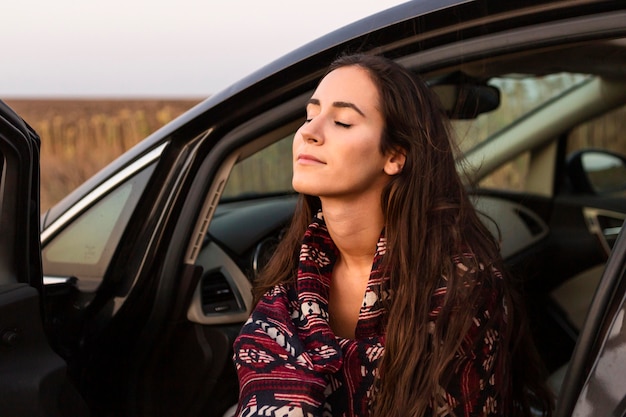 Side view of woman enjoying nature in the car