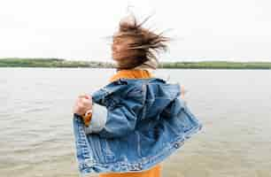 Free photo side view woman enjoying sea breeze