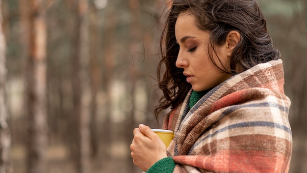 Donna di vista laterale che gode della tazza di tè