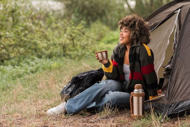 Free photo side view of woman enjoying the view while camping outdoors