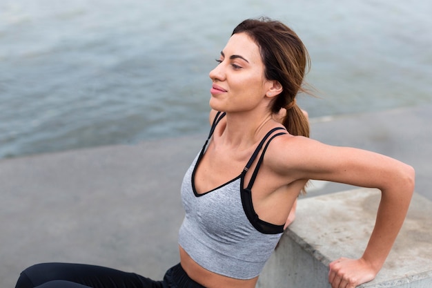 Side view of woman exercising outdoors by herself