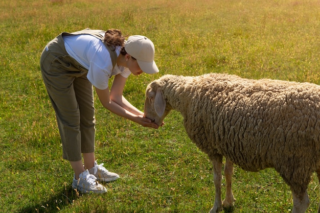 Side view woman feeding sheep
