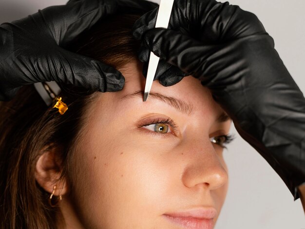 美容師が眉毛を整える女性の側面図