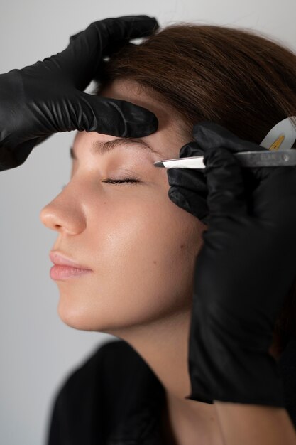 Side view of woman getting her eyebrows done