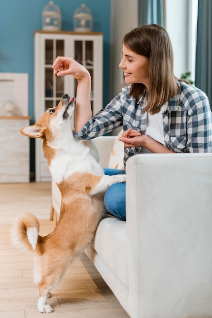 彼女の犬に御馳走を与える女性の側面図