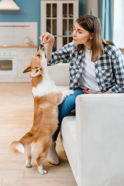 Side view of woman giving her dog treats