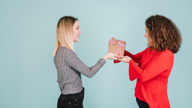 Side view woman giving present to mother