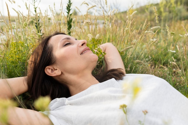 Вид сбоку женщины в траве на открытом воздухе