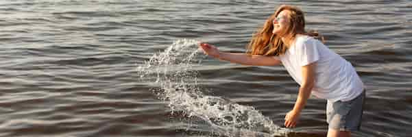 Free photo side view of woman having fun in the water with copy space