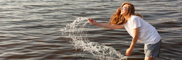 コピースペースで水中で楽しんでいる女性の側面図