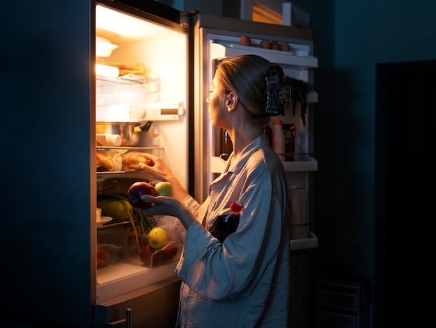 Free photo side view woman having snacks