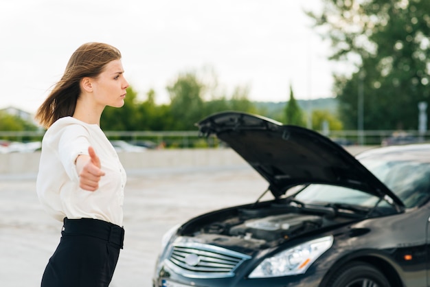 Side view of woman hitchhiking