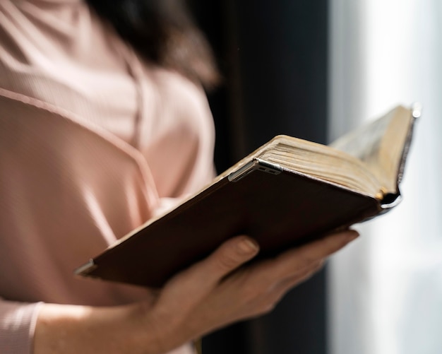 Side view of woman holding bible