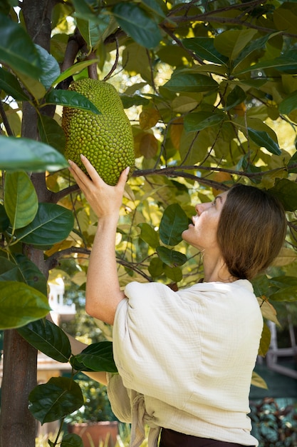 Free photo side view woman holding big fruit