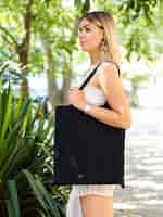 Free photo side view woman holding a black bag