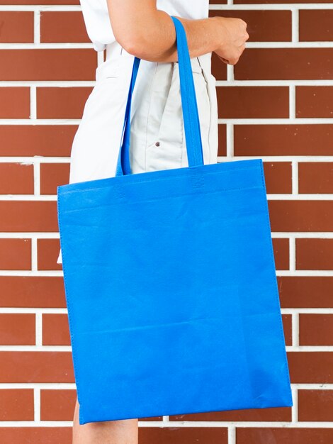 side view woman holding a blue bag mock-up