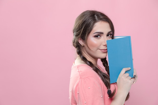 Side view of woman holding book close to face