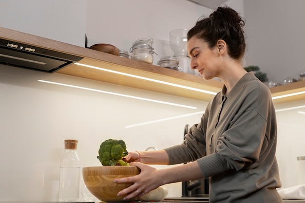 Side view woman holding broccoli