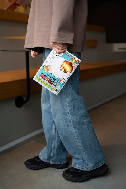 Free photo side view woman holding comics