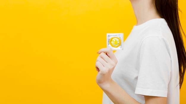 Женщина, держащая презерватив с копией пространства