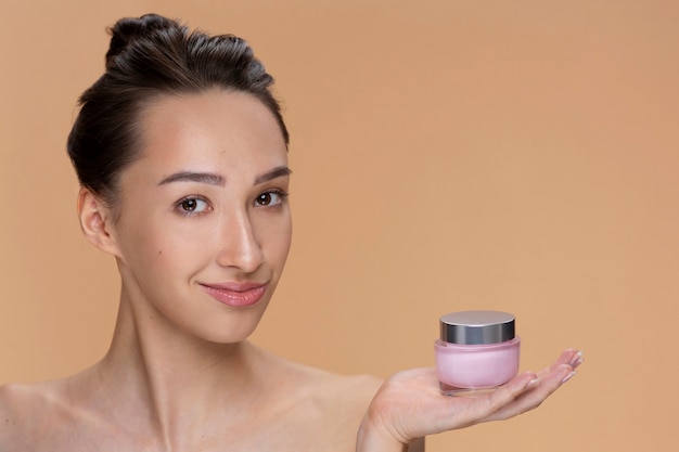 Side view woman holding cream container