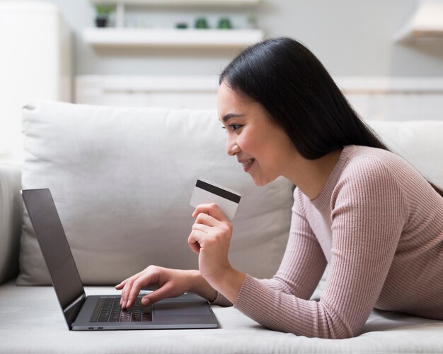 クレジットカードを保持しているとオンラインで注文する女性の側面図