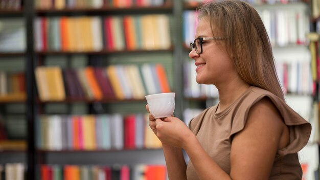 side view woman holding cup