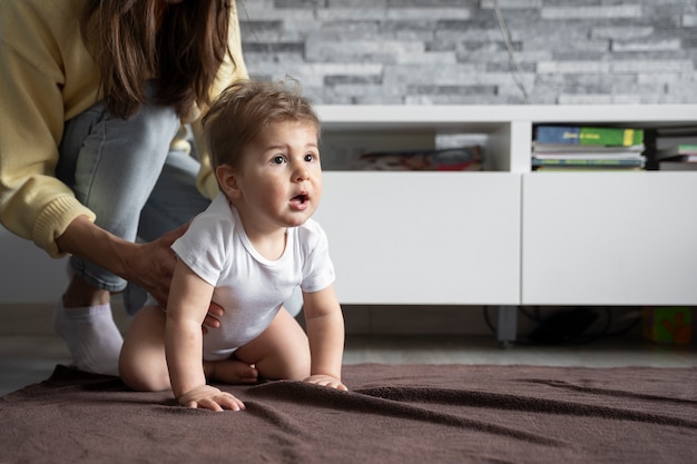 Free photo side view woman holding cute baby