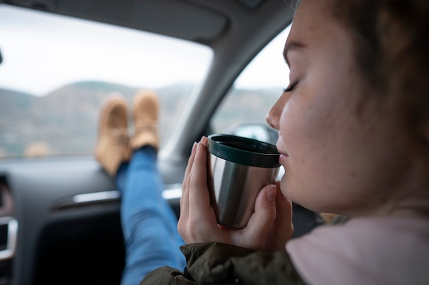 飲み物を持っている側面図の女性