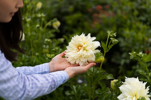 Foto gratuita fiore della holding della donna di vista laterale