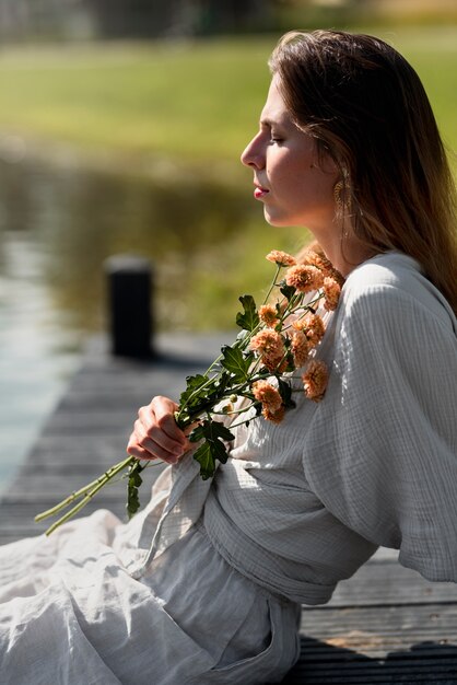 Side view woman holding flowers bouquet