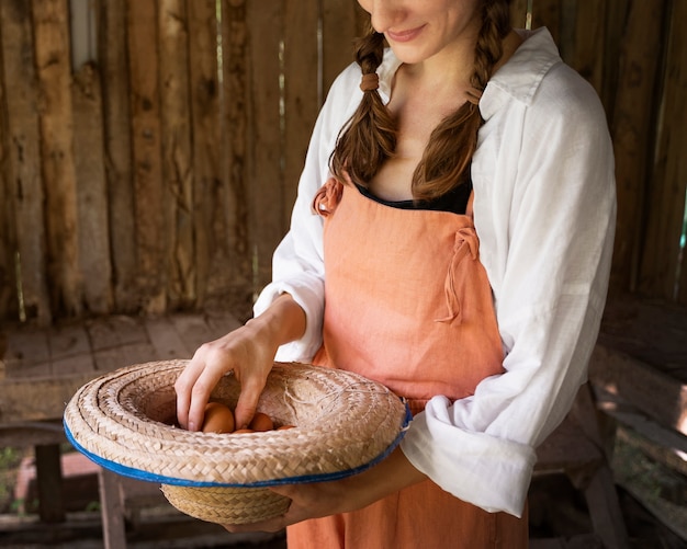 Foto gratuita cappello della holding della donna di vista laterale con le uova