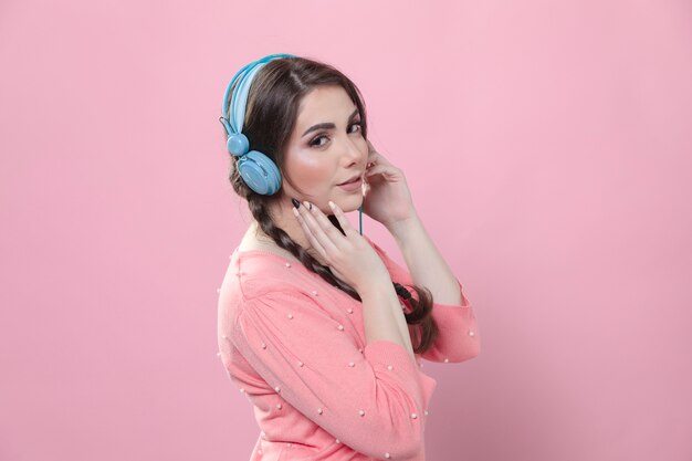 Side view of woman holding headphones on her head