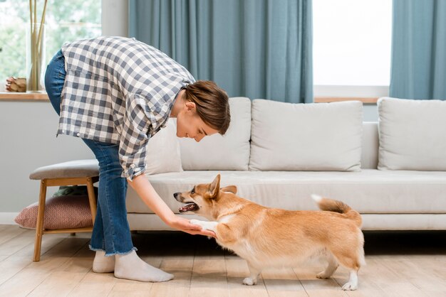 彼女の犬の足を保持している女性の側面図