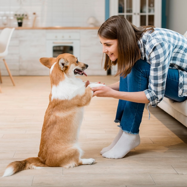 彼女の犬の足を保持している女性の側面図