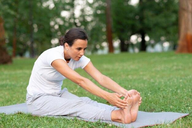 Side view woman holding her feet