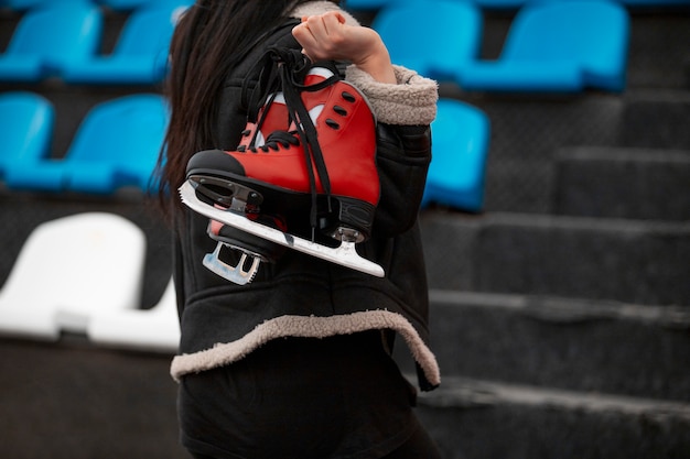 Free photo side view woman holding ice skates